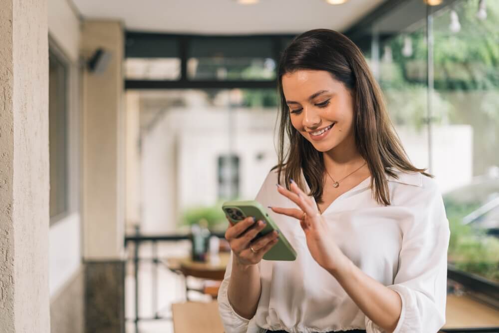 A happy customer smiling while using a business on her phone